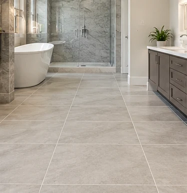 Pale ceramic floor tiles with a glass shower and bathtub